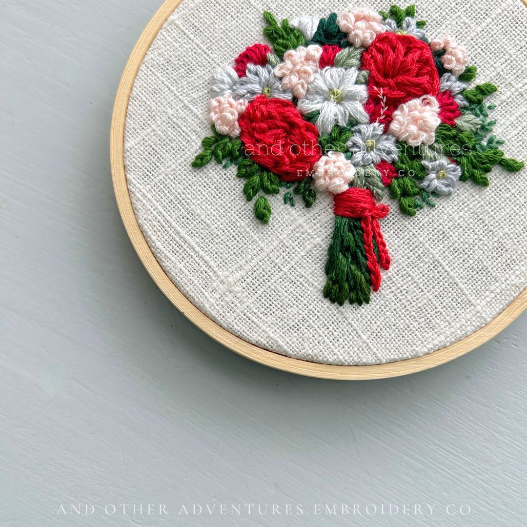 Wintery Holiday Bouquet with red, blush and icy blue blooms with cascading evergreen leaves - hand embroidered by And Other Adventures Embroidery Co