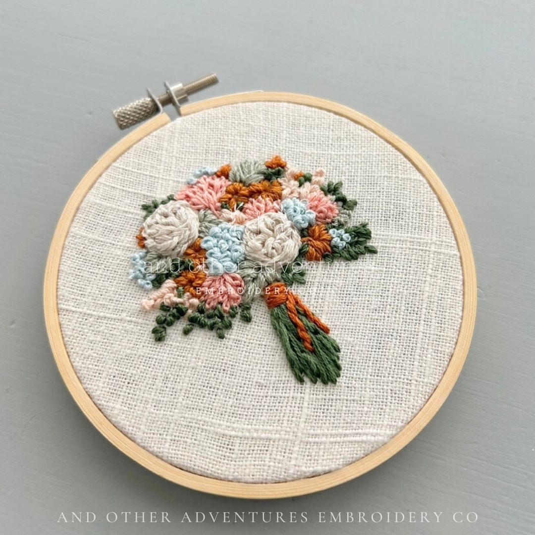 Soft silvery blue, peach and ivory tones combine with the pop of mustard gold creates a hand embroidered bouquet that feels like summer fading into fall. Stitched by And Other Adventures Embroidery Co