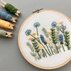 Spring flowers hand embroidery design in blue and yellow by And Other Adventures Embroidery Co