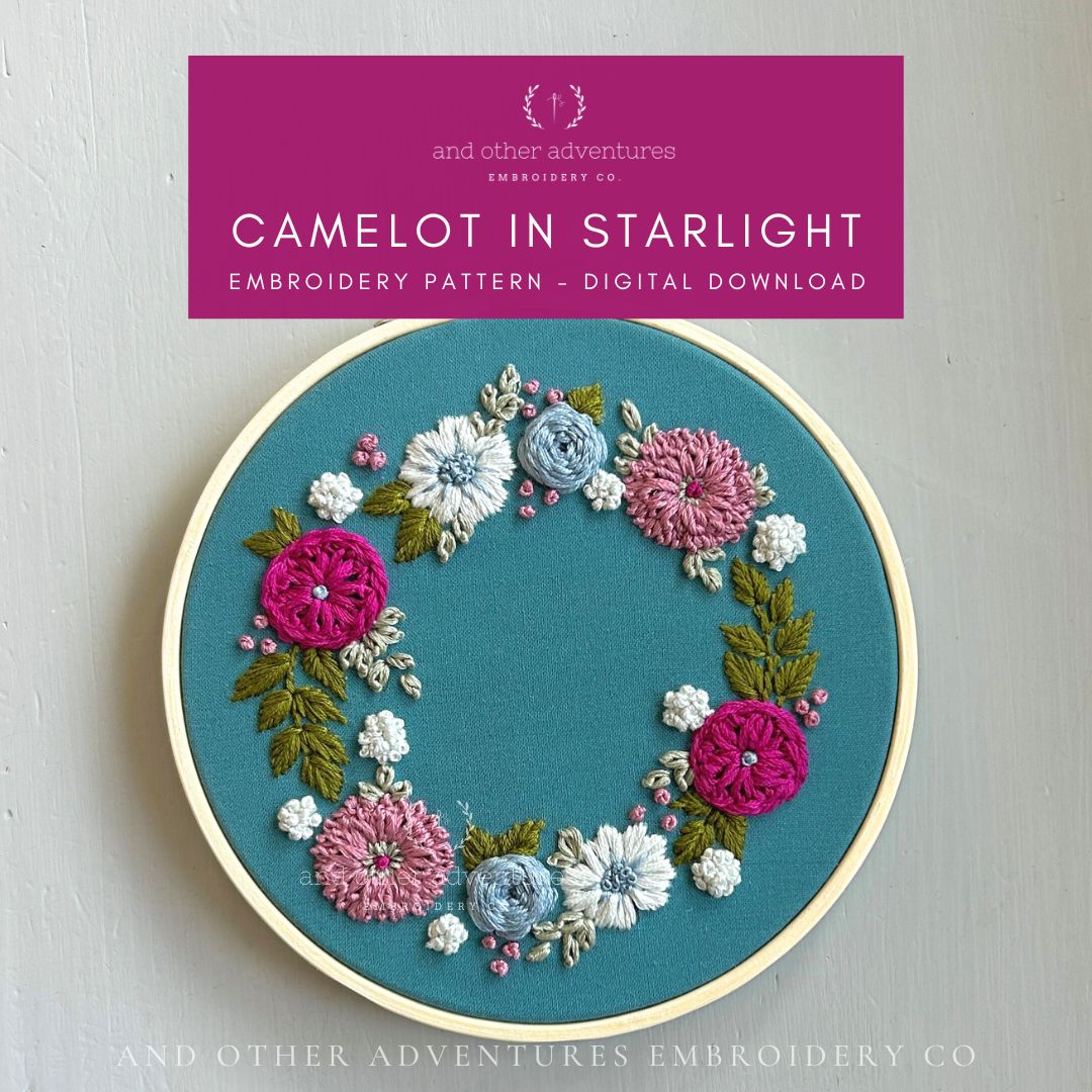 Embroidery hoop with floral design on a teal background, featuring 'Camelot in Starlight' embroidery pattern by And Other Adventures Embroidery Co.