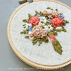 Beautiful Embroidery bouquet with floral embroidery design on a gray surface, featuring &#39;And Other Adventures Embroidery Co&#39; branding.