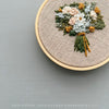 3&quot; Embroidery hoop with hand stitched floral design hand embroidered by &#39;And Other Adventures Embroidery Co branding.