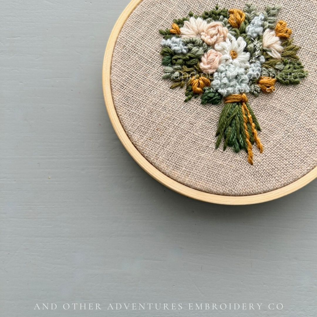 3" Embroidery hoop with hand stitched floral design hand embroidered by 'And Other Adventures Embroidery Co branding.