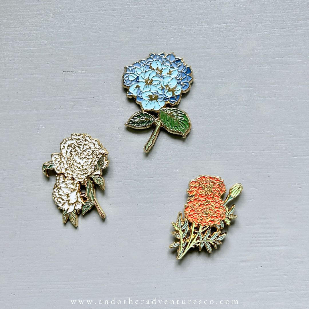 Three enamel needle minders sold by And Other Adventures Embroidery Co