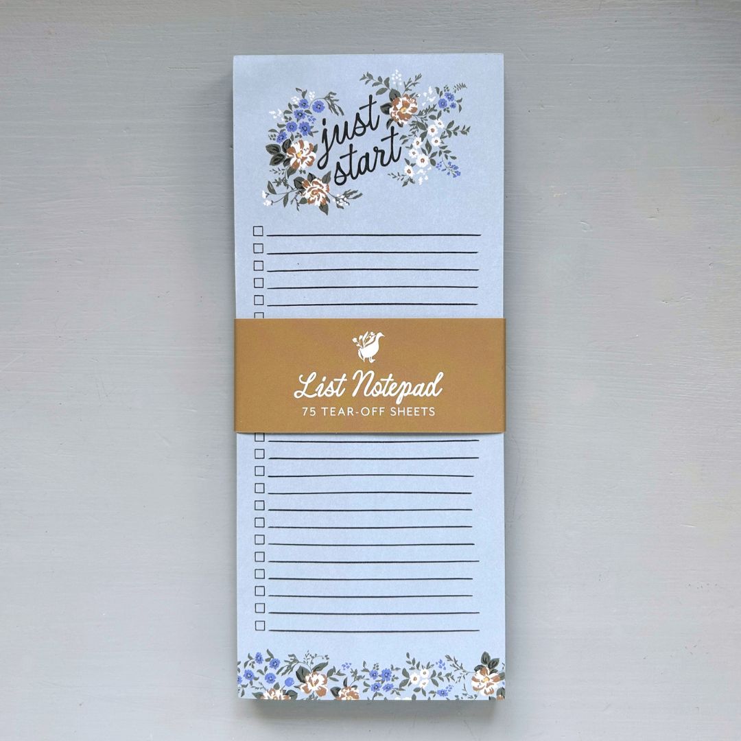 Notepad with floral design and text on a light gray background
