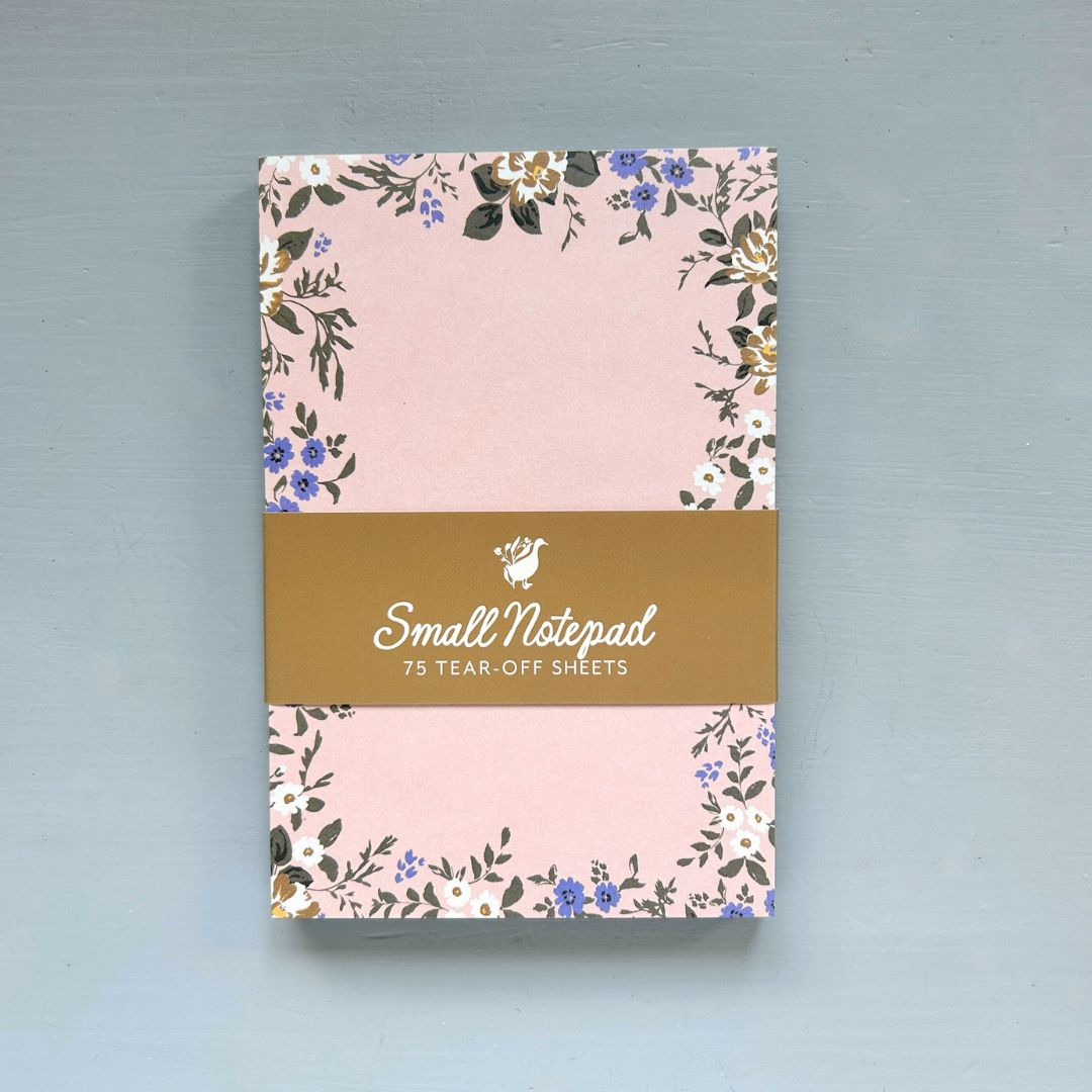 Small notepad with floral design on a pink background